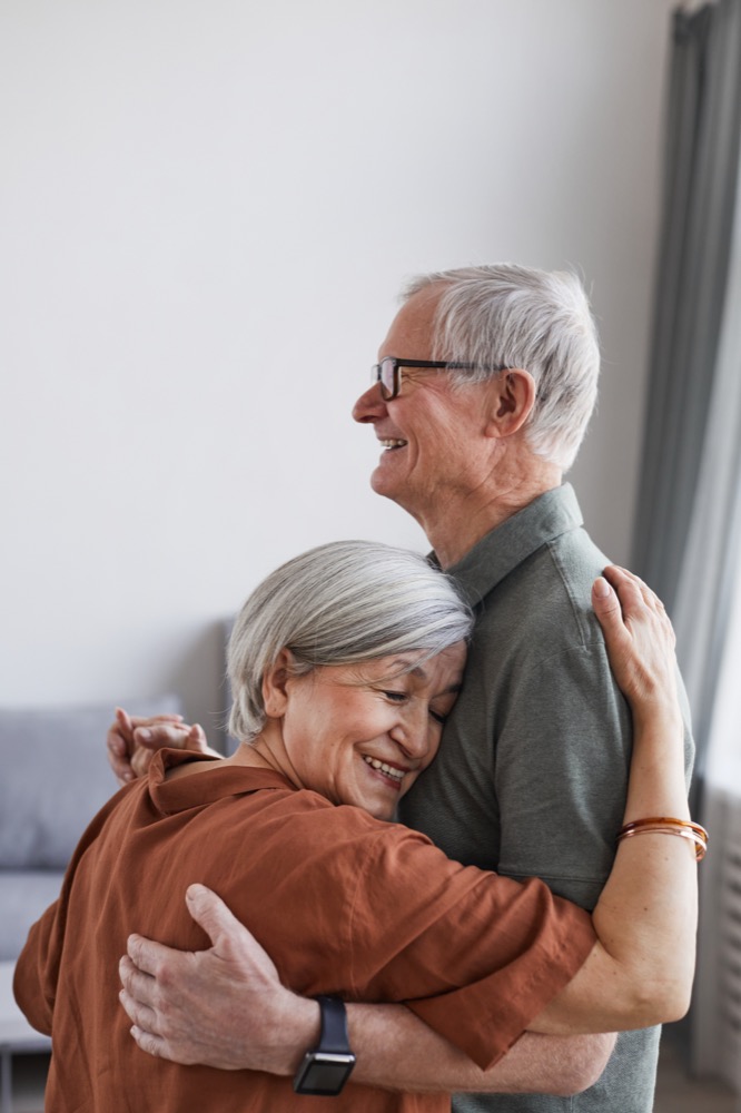 An older couple embracing at home